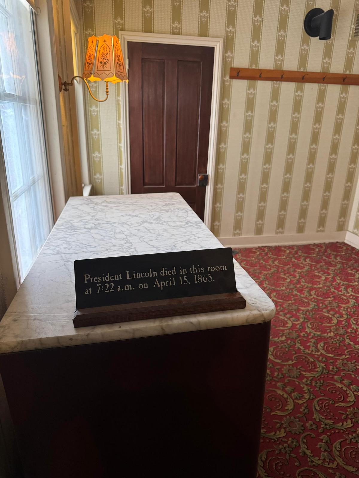 A marker on the bed in the back room of Petersen House reading: President Lincoln died in this room at 7:22 a.m. on April 15, 1865